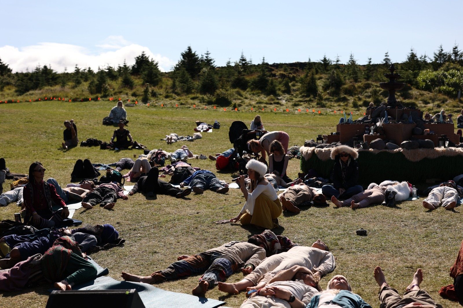 A field of people lying in the sun with eyes closed as Leanne sings among them