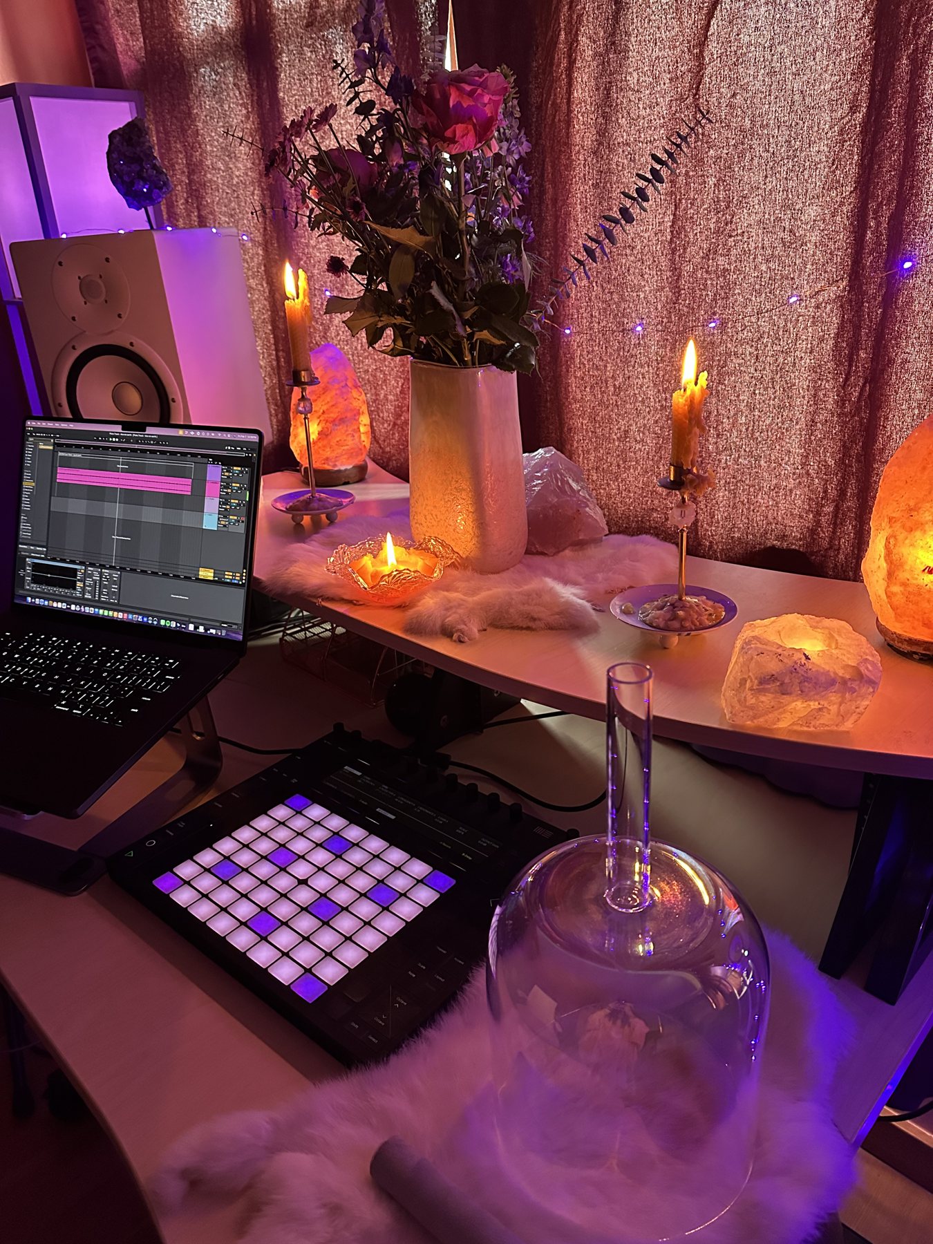 Leanne's studio altar: a crystal singing bowl, a glowing pad controller, salt lamps, candles and roses